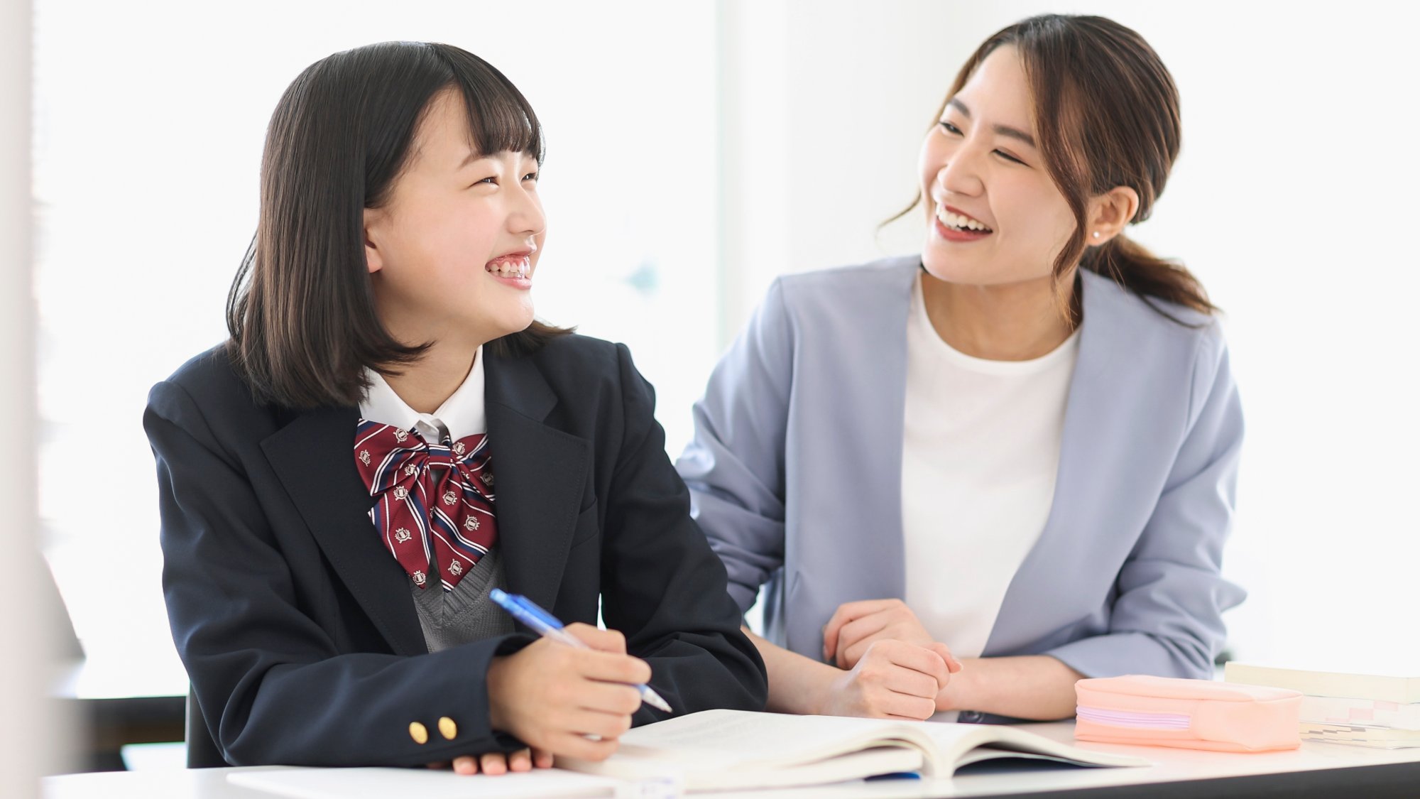 女性教師と女子高生が笑顔で授業