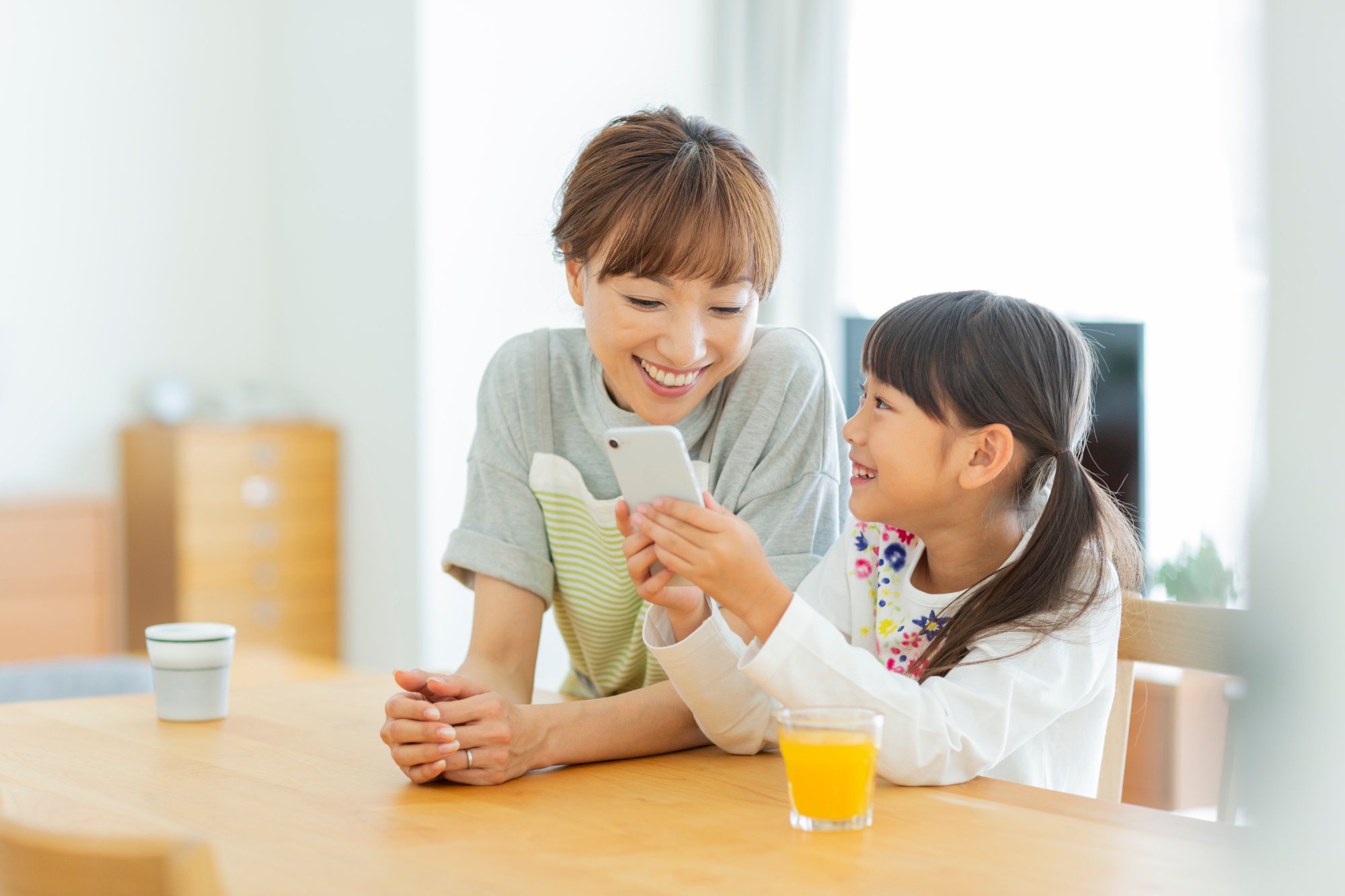 母親と娘がスマホで家庭教師を探すシーン